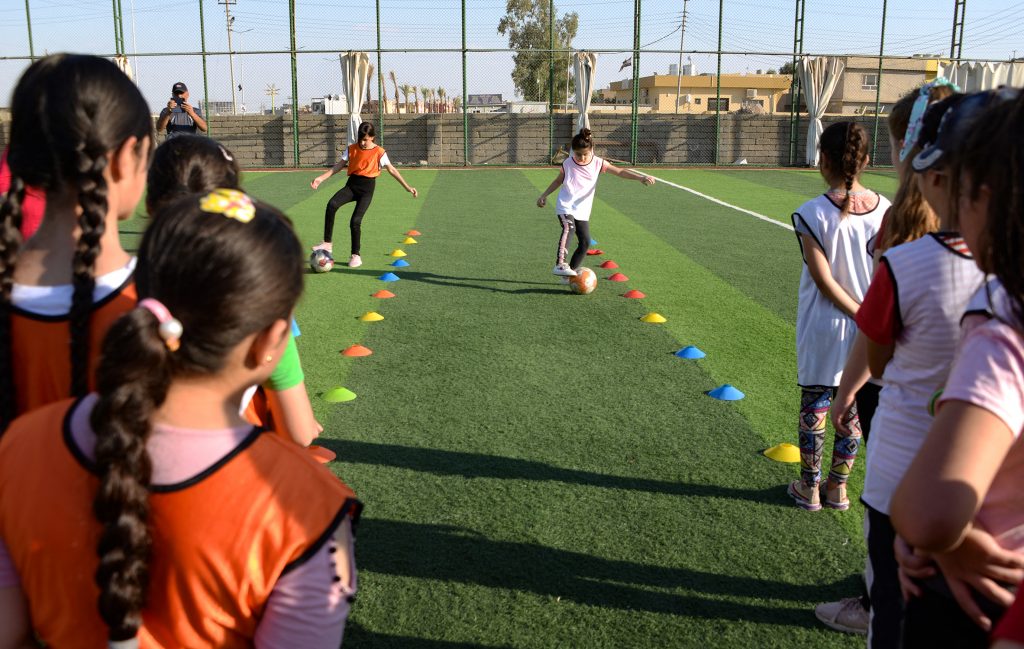 Niñas superan las huellas de la guerra entrenando fútbol 4 Niñas superan las huellas de la guerra entrenando fútbol Una academia de fútbol para niñas, con una cancha de césped artificial, abrió sus puertas hace seis meses gracias al apoyo financiero de Lara, una ONG cristiana iraquí. Allí, motivadas por su entrenadora, niñas cristianas patean el balón en una cancha en la localidad iraquí de Bartalla, un antiguo bastión yihadista donde el fútbol les permite soñar con un mejor futuro.