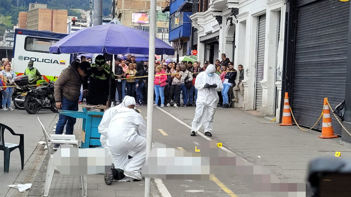 En plena Avenida Caracas sicario mató a dos jóvenes 1 En plena Avenida Caracas sicario mató a dos jóvenes Una vainilla de bala y una placa pequeña amarilla que demarcaba un número ‘2’ quedaron sobre el carro de ventas de forros de celulares de sombrilla azul, frente al cual asesinaron a dos venezolanos la tarde de ayer. La Caracas se vistió de muerte. Otras cinco placas se hallaban esparcidas por el andén de la Avenida Caracas con Calle 13, demarcando los seis balazos con los que un sicario cometió este doble crimen.