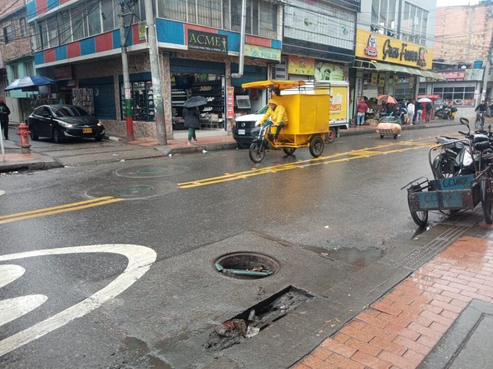 Mujer falleció por una alcantarilla sin tapa en El Amparo, en Kennedy Según vecinos, la escena se repite a diario: “sin exagerar acá pasan, mínimo, dos accidentes al día, claro que no tan graves como el de esta mañana, ¿no? Pasa mucho que un carro atropelló una moto, que un bus arrolló a alguien, que un taxi chocó otro carro, que una bicicleta se voló un semáforo y la atropellaron, y así. Todos los santos días pasa alguna vaina de tránsito. Y cuando no es eso, entonces que apuñalaron a alguien por robarlo, que atracaron una tienda, que le dispararon a no sé quién y lo que usted se imagine, ¡este barrio es cosita seria! Y últimamente está más candela que de costumbre, eso por acá es tierra de nadie”, le dijo a Q'HUBO un comerciante del barrio El Amparo, en Kennedy