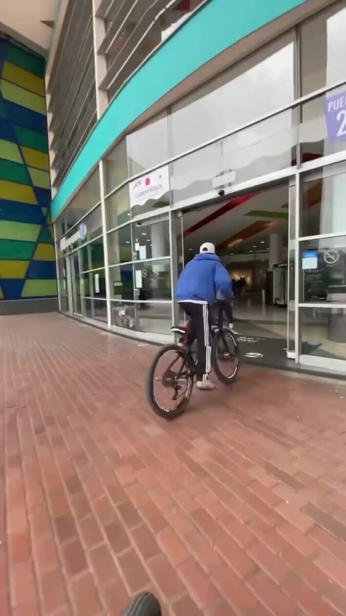 Jóvenes se metieron a hacer acrobacias en bicicleta en un centro comercial En otra grabación, tomada desde el segundo piso, se ve el momento exacto en que uno de los jóvenes es alcanzado por un guarda y cae al piso tras ser aprehendido.